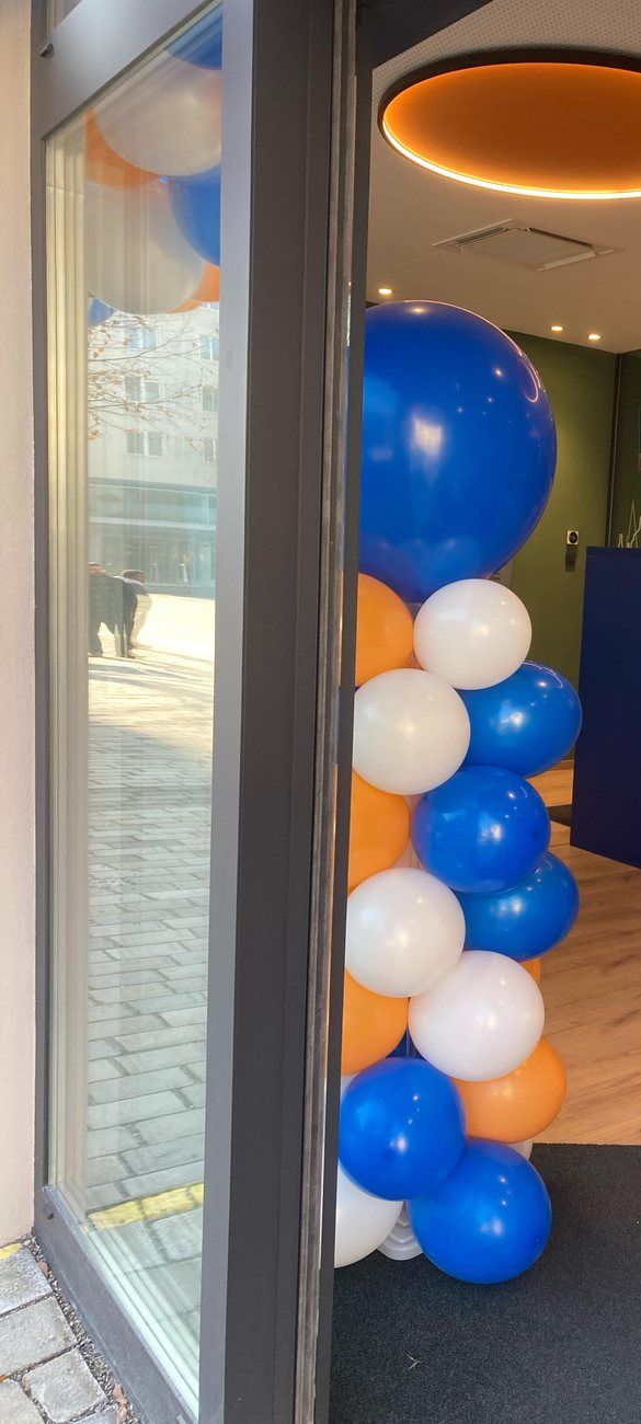 Ballonsäule in Blau, Orange und Weiß am Filialeingang