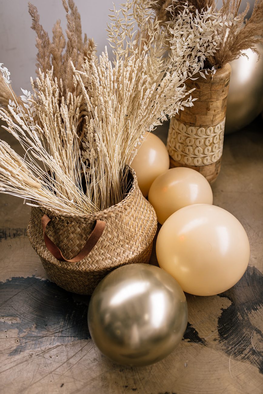 Hochzeitsdekoration mit Gold-Ballons, Pampasgras und Naturkorb